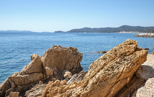 A rocky beach with a view of the sea and mountains in the background