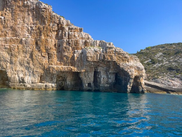 Photo a rocky cliff with a cave on the side and a large hole in the middle