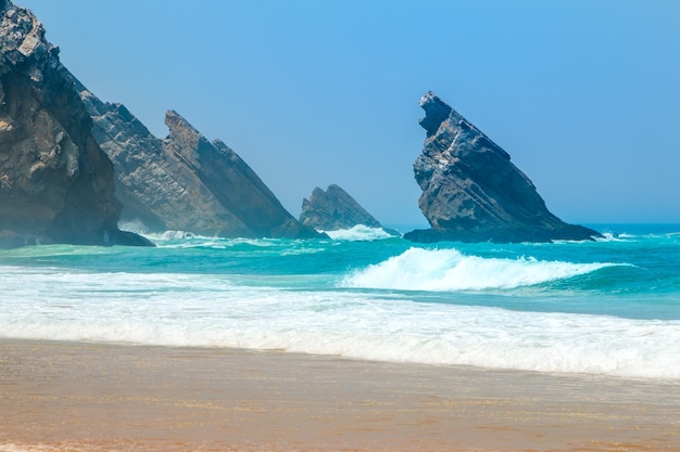 Rocky coast of the Atlantic Ocean. Sunny weather and blue sky. Surf