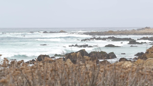 Rocky craggy ocean coast sea water waves crashing on rocks monterey california