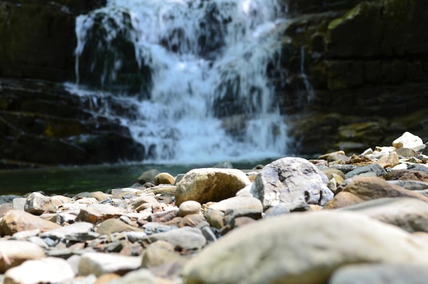 A rocky foreground and waterfall in the background