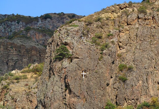 rocky hill with white cross view from geghard monastery near goght in kotayk province armenia