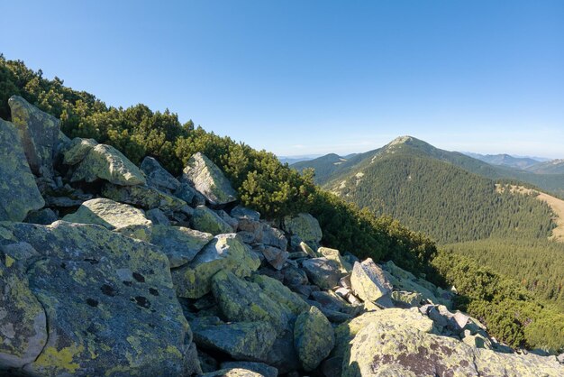 Rocky mountain hillside with big stone boulders on sunny day