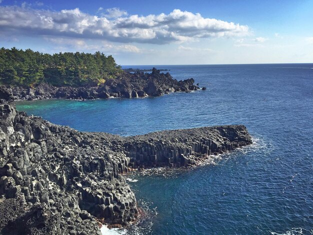 Photo rocky mountains by sea against sky