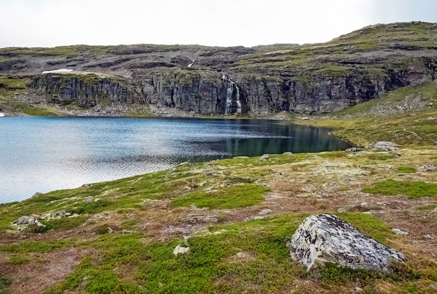 湖と滝のあるノルウェーの岩の多い風景