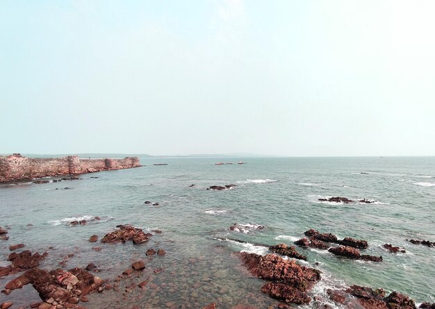 Photo a rocky outcrop with a rock outcropping in the water