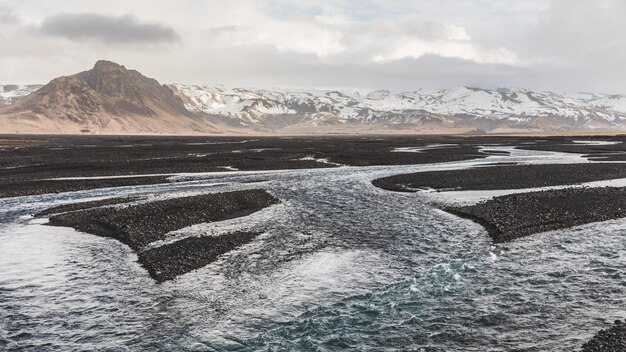 Rocky riverbed and stream with mountains 