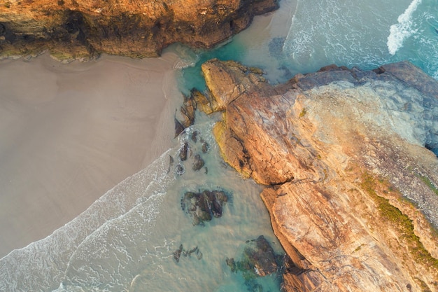 Rocky sea coast at sunrise Beach Playa de Las Catedrales in Ribadeo Spain Europe Aerial view