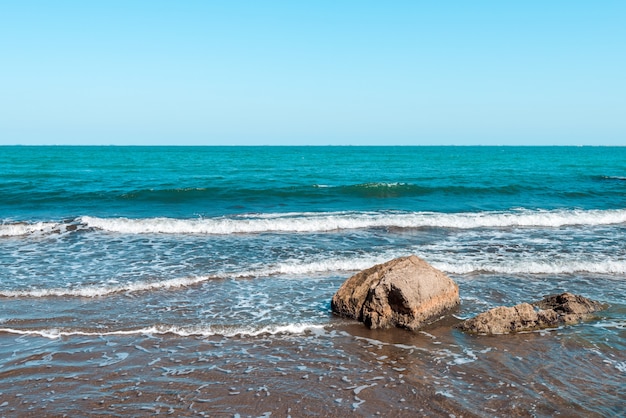 Скалистое морское побережье с бирюзовой водой на пляже