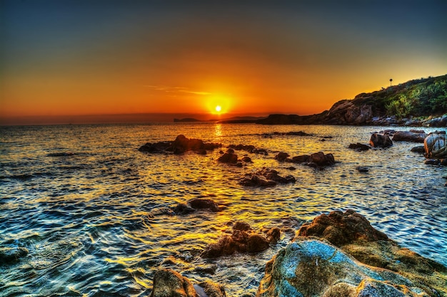 Rocky shore in Alghero at sunset Sardinia