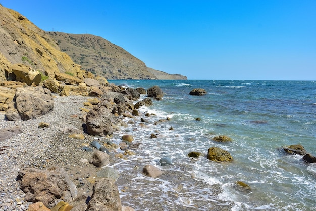 海から突き出ている海岸の岩の上の岩と黒海の風景の岩の多い海岸