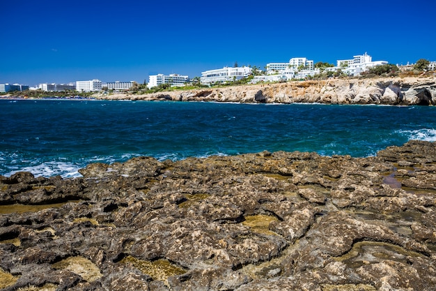 Rocky shore, clear turquoise sea water and blue sky in Ayia-Napa, Cyprus, hotels.