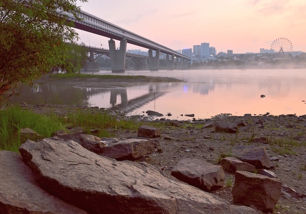 rocky shore of the ob in novosibirsk big stones on the riverbank bridges