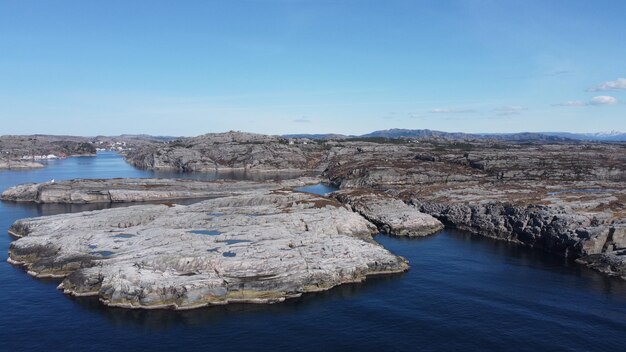 A rocky shore with a blue sky and the sea in the background.