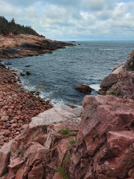 a rocky shoreline with a body of water in the background