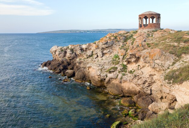 Rocky summer coastline and cape with pavilion