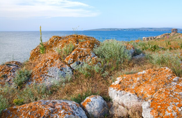 Rocky summer coastline and cape with pavilion