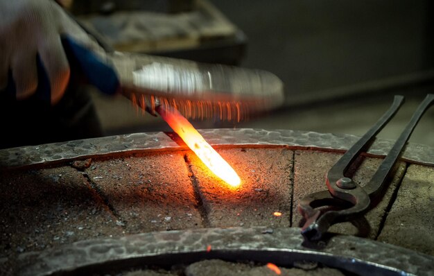 Rod of red hot forging steel at the blacksmith's