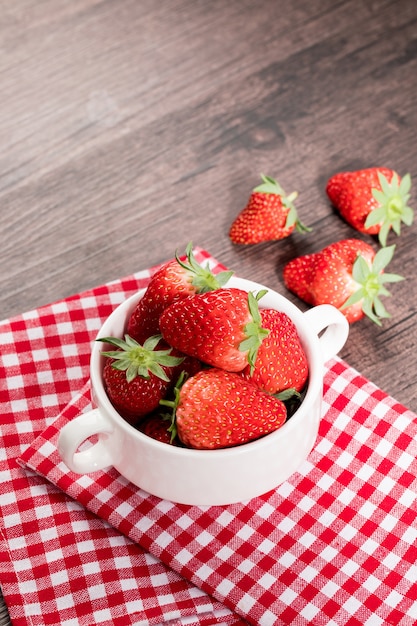 Rode aardbeien geïsoleerd in kom op tafel