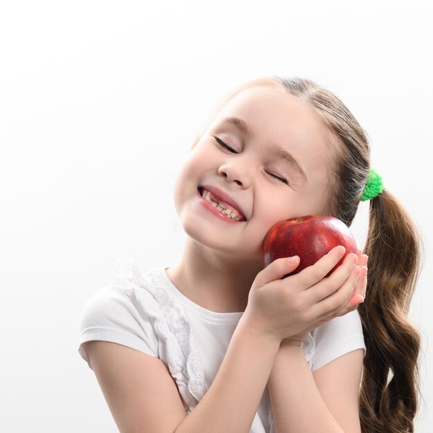 Rode appel en klein meisje portret van een kind op een witte achtergrond