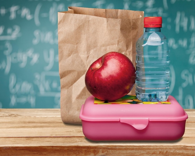 Rode appel met water en eten op de schoolbank