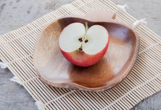 Foto rode appel op witte houten schotel