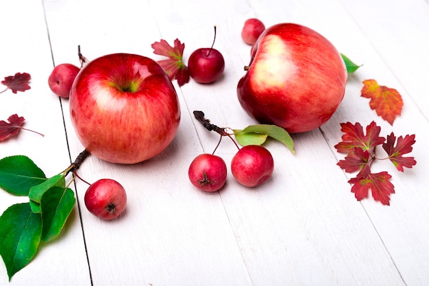 Rode appels en bladeren op houten vloer