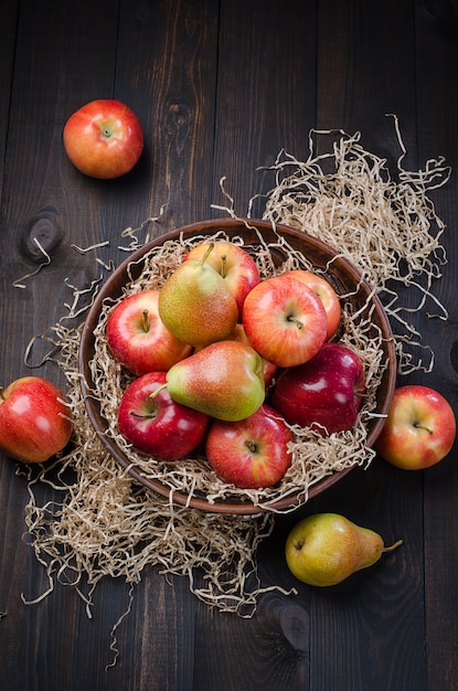 Rode appels en peren op een houten donkere rustieke achtergrond.