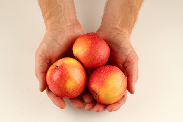 Rode appels Florina in de handen op een wit oppervlak