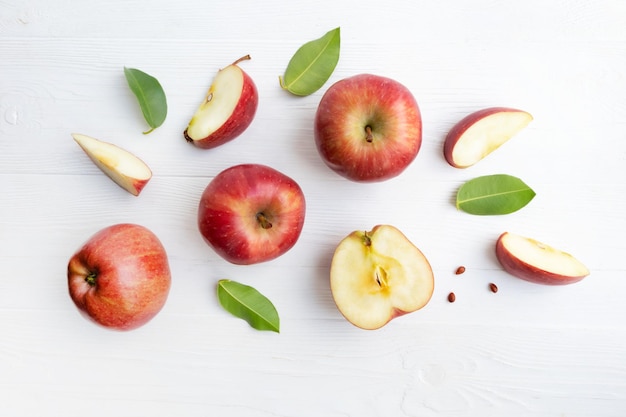 Rode appels geheel en stukken met bladeren op een witte achtergrond poster