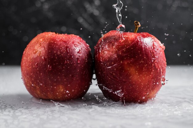 Rode appels in een bord met waterdruppels