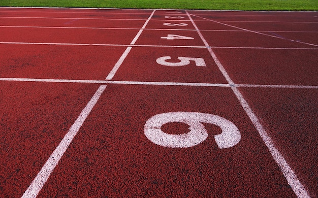 Rode atletiekbaan loopband in het stadion met de nummering.