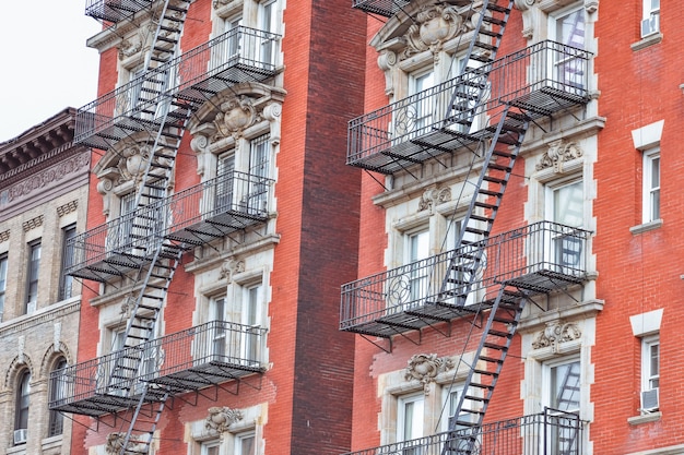 Rode bakstenen gevel en brandtrap. Harlem, NYC.