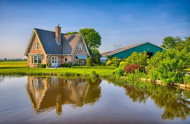 Rode bakstenen huis op het platteland in de buurt van het meer met spiegelreflec