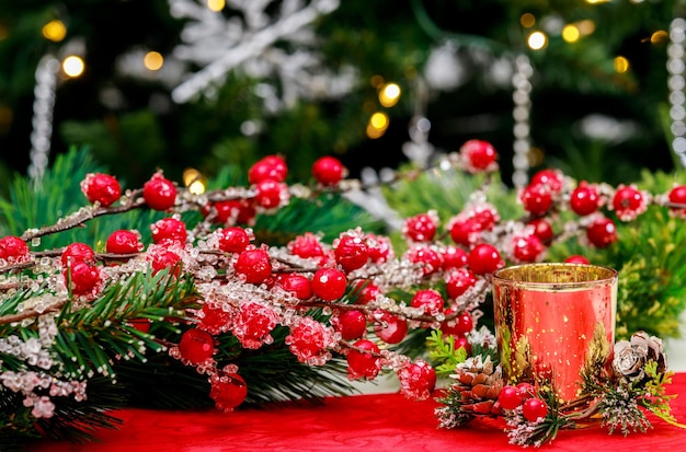 Rode bessen en een brandende kaars op kerstachtergrond