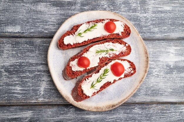 Rode bietenbroodsandwiches met roomkaas en tomaten