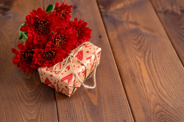 Rode bloemen en ambachtelijke geschenk op een houten bord. Valentijnsdag achtergrond. St.Valentines Day kaart concept