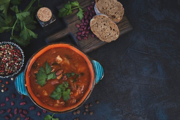 Rode bonensoep met kruiden en specerijen op een donkere tafelondergrond. gezond eten. traditionele keuken.