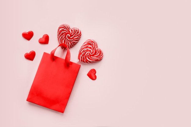 Rode boodschappentas met twee hartvormige lolly's op roze Valentijnsdag achtergrond