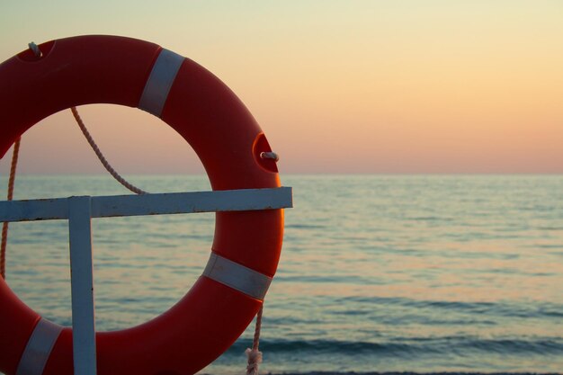 Foto rode boot op zee tegen de hemel bij zonsondergang