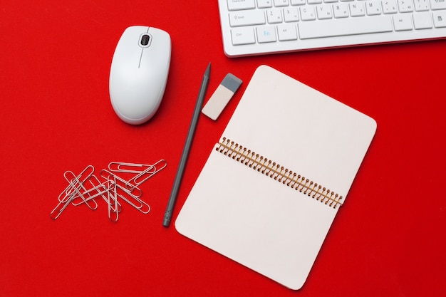 Foto rode bureau tafel met briefpapier en kantoorbenodigdheden