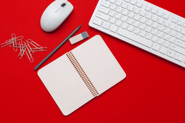 rode bureau tafel met briefpapier en kantoorbenodigdheden