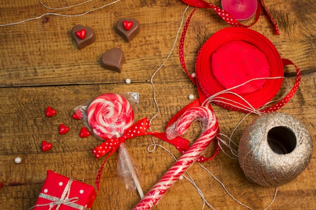 Rode cadeaus, snoep, ballonnen, lollyjes, chocolade harten op houten tafel. Valentijn decoratie