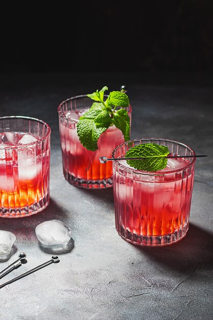 Rode cocktails met cranberry, muntblaadjes en ijsblokjes