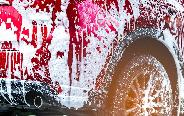 Rode compacte SUV-carwash met schuim voor glaswassen en glascoating.