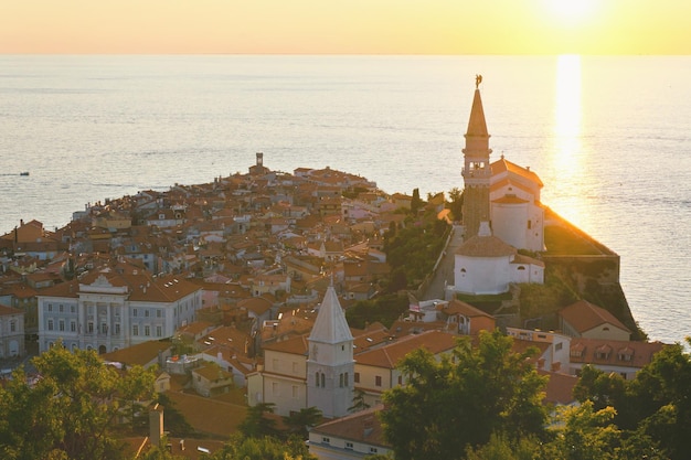 rode daken van het historische centrum van de oude stad Piran, Slovenië. hoofdkerk. zonsondergang hemel. Reis. Zee