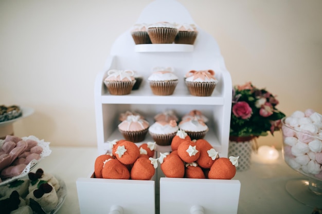 Foto rode donuts en gebak in witte houten kisten op een desserttafel candy bar