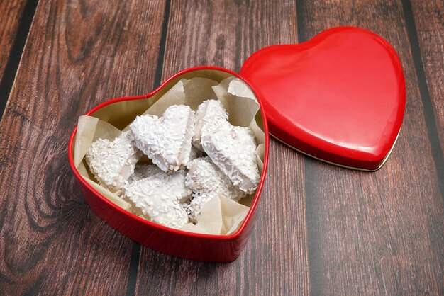 Rode doos met hartvorm en smakelijke koekjes met kokos, zoete Valentijnsdag concept