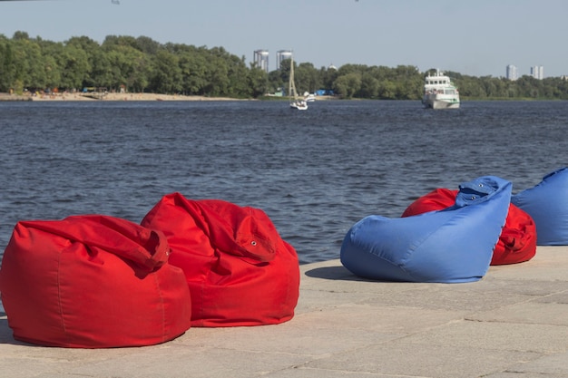 Rode en blauwe strandzitzakken op de oever van de rivier