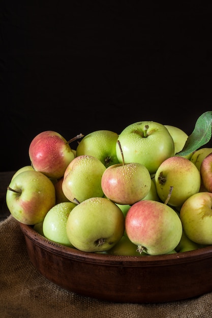 rode en groene appels hout achtergrond. Appels in kom. Tuin vruchten. Herfst fruit.